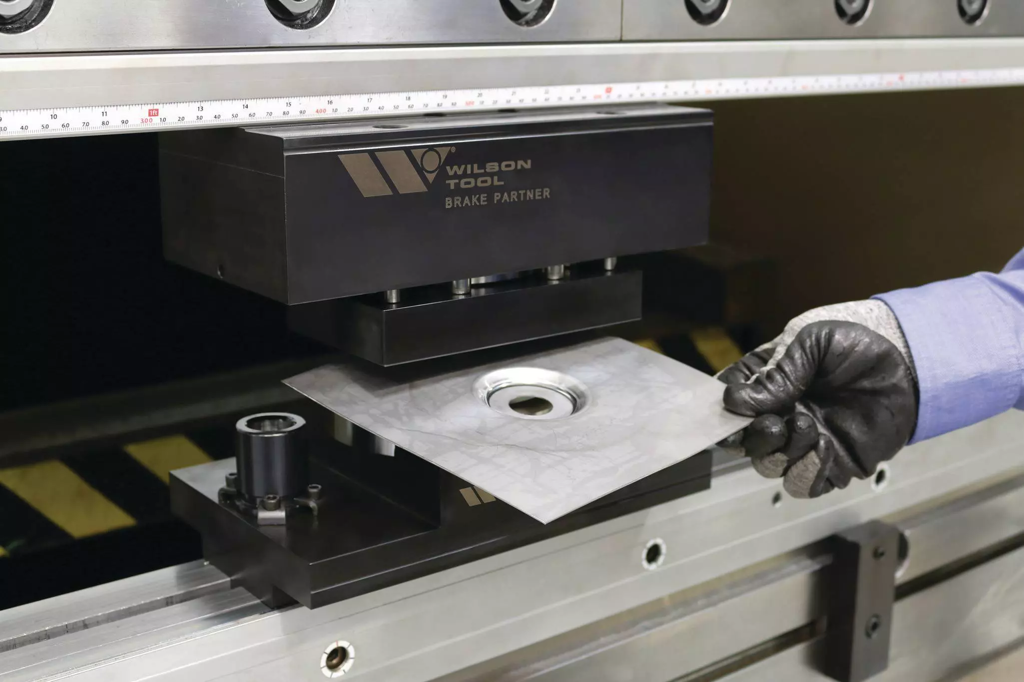 Image of person punching in press brake