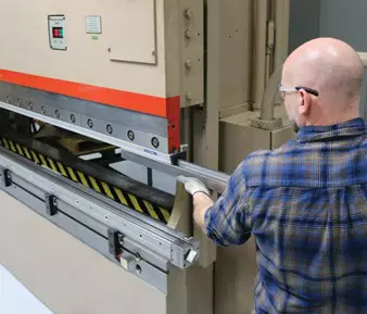 worker replacing a dove style replaceable radius press brake punch tip