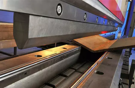Close-up of thick material being bent in a press brake