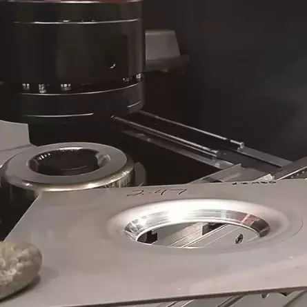 sheet metal with a large formed countersink and special press brake tooling in machine in background