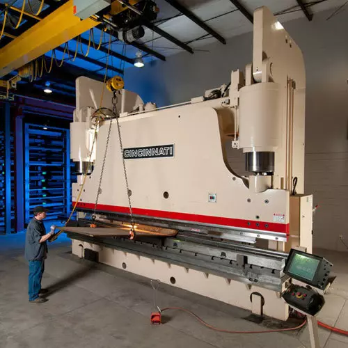 Press brake operator workign with a large press brake image